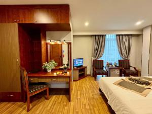 a hotel room with a desk and a bed at Gllant Villa Hà Nội in Hanoi