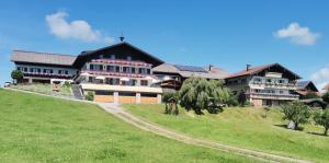 a large house on top of a green field at Stiedlbauerhof in Seeham