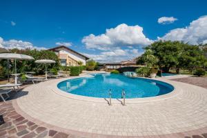 a large swimming pool with chairs and umbrellas at Agriturismo Parmenide in Castelnuovo Cilento