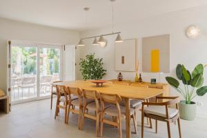 a kitchen with a wooden table and chairs at Villa Vintage, By Home Match in Azeitao