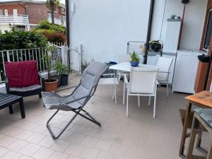 a chair and a table and chairs on a patio at La Casetta 115 fronte lago in Castelletto sopra Ticino