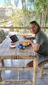 a man sitting at a table with a plate of food at Melody Surf Ekas Lombok in Ekas