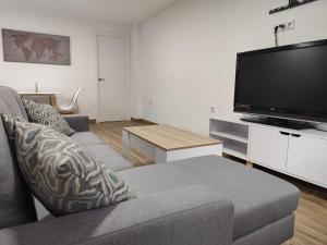 a living room with a couch and a flat screen tv at Las Nubes Mairena in Mairena del Aljarafe