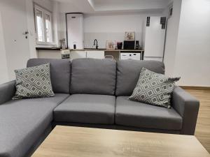 a grey couch with pillows in a living room at Las Nubes Mairena in Mairena del Aljarafe