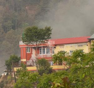 a building on top of a hill with trees at TheLocals HomeStay in Dhulikhel