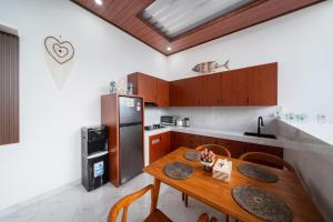 a kitchen with a wooden table and a refrigerator at Anta Villa Lembongan in Nusa Lembongan