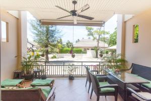 a patio with tables and chairs and a ceiling fan at Southern Lanta Apartments in Ko Lanta