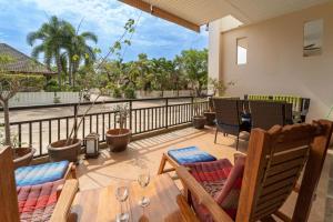 a patio with chairs and a table and a balcony at Southern Lanta Apartments in Ko Lanta