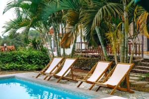 a group of lounge chairs next to a swimming pool at Cat Ba Spring Homestay in Cat Ba