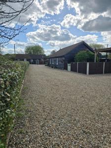 a gravel driveway in front of a house at Oak Cottage with private log fired hot tub in Maidstone