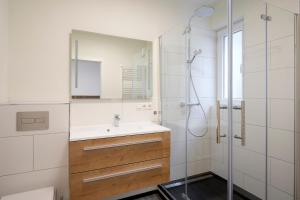 a bathroom with a sink and a shower with a mirror at Gästehaus am Weinberg in Oberheimbach
