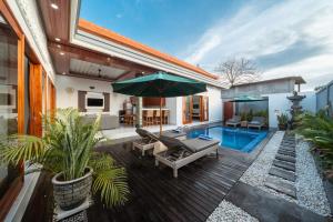a backyard with a swimming pool and a house with a patio at Anta Villa Lembongan in Nusa Lembongan