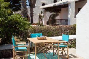 a wooden table and chairs on a patio at San Colomban in Sant Lluis