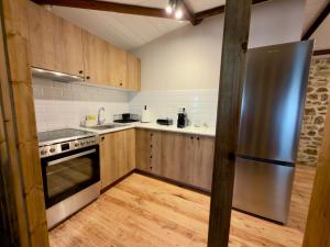 a kitchen with wooden cabinets and a stainless steel refrigerator at Eleon apartments in Kalamata