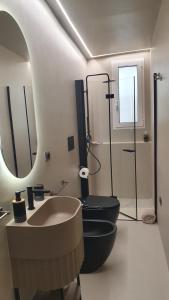 a bathroom with two black toilets and a sink at Villetta Angela in Torre San Giovanni Ugento