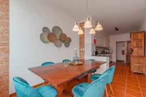 a dining room with a wooden table and blue chairs at Setúbal Oasis House, By Home Match in Setúbal
