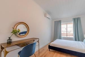 a bedroom with a bed and a desk and a mirror at Setúbal Oasis House, By Home Match in Setúbal +28 photos