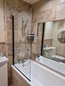 a bathroom with a shower and a tub and a sink at PR 2 BR Modern Home in Middlesbrough +25 photos