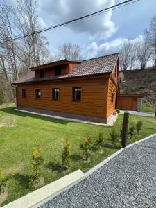 a large wooden house on the side of a road at Chalupa Nella in Velké Karlovice