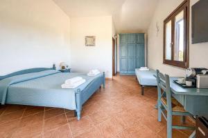 a bedroom with a blue bed and a desk at Tegghja Country Suites in Rena Majore