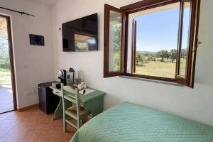 a bedroom with a bed and a desk and a window at Tegghja Country Suites in Rena Majore +3 photos