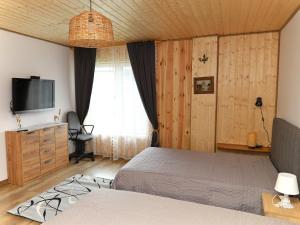 a bedroom with a bed and a flat screen tv at Ostoja Tatary Agroturystyka in Tykocin