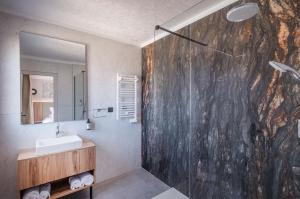 a bathroom with a shower with a sink and a mirror at The Originals city, Hôtel Harys in Vichy