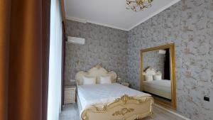 ein Schlafzimmer mit einem Bett und einem Spiegel in der Unterkunft Siena Hotel in Odessa