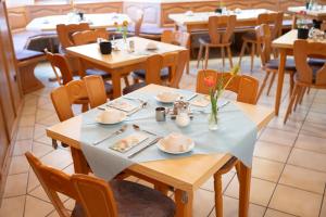 a dining room with tables with plates and utensils at Gästehaus Willanzheim in Willanzheim