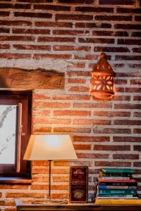 a lamp on a table next to a brick wall at Casona del Tambor in Calatañazor