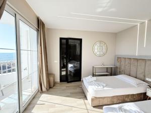 a bedroom with a bed and a large window at Elko Apartments & Rooms in Golem +150 photos