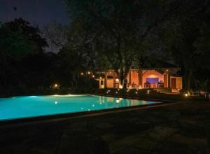 a swimming pool at night with a house in the background at vainika wild sigiriya in Sigiriya