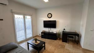 a living room with a couch and a tv and a table at Maison T2 avec terrasse et cours de 50m2 in Sorgues