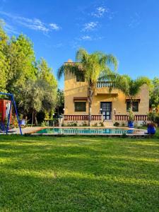 ein Haus mit einem Spielplatz vor dem Garten in der Unterkunft Villa Eden Atlas Ourika in Sbiti