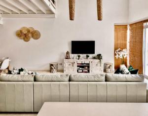 a living room with a couch and a flat screen tv at Dolphin View 34 in Langstrand