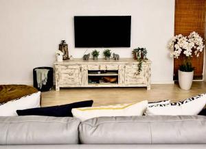 a living room with a couch and a flat screen tv at Dolphin View 34 in Langstrand