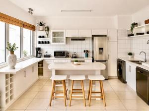a white kitchen with a table and stools at Dolphin View 34 in Langstrand