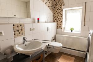 a white bathroom with a sink and a toilet at Ferienwohnung Otto in Pegnitz +13 photos
