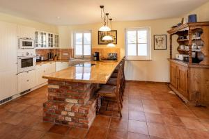 a kitchen with a brick island in the middle at Alte Büdnerei 1 Abeking-Haus in Althagen