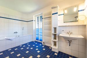 a bathroom with a sink and a tub and a toilet at Alte Büdnerei 1 Abeking-Haus in Althagen +11 photos
