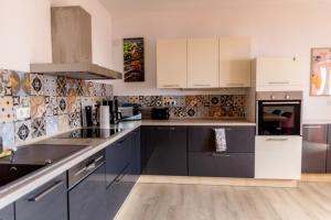 a kitchen with white cabinets and gray appliances at Ferienwohnung Otto in Pegnitz
