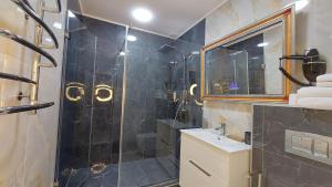 ein Badezimmer mit Dusche, Waschbecken und Spiegel in der Unterkunft Siena Hotel in Odessa + 69 Fotos