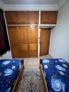 ein leeres Zimmer mit zwei Betten und Holzschränken in der Unterkunft Villa Eden Atlas Ourika in Sbiti