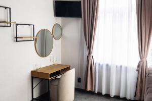 a room with a desk and a mirror and a window at Family Boutique in Veliko Tŭrnovo +2 photos