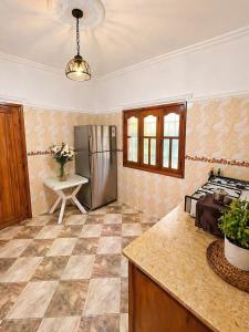 eine Küche mit einem Edelstahlkühlschrank und einem Tisch in der Unterkunft Villa Eden Atlas Ourika in Sbiti + 15 Fotos