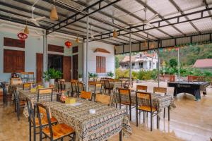 a restaurant with tables and chairs and a piano at Cat Ba Spring Homestay in Cat Ba