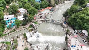 an aerial view of a river with a waterfall at The Cozy Cottage in Kundālshai +1 photo
