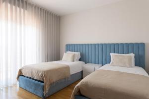 two beds sitting next to each other in a bedroom at Colinas Premium 3BR in Odivelas