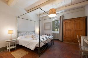 a bedroom with a canopy bed and a table at Tenuta La Fratta in Sinalunga +55 photos