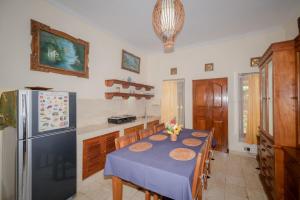 a kitchen with a table and a refrigerator at Villa Riens Dream in Karangasem